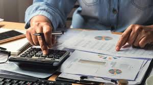 professional analyzing financial reports and using a calculator to ensure accuracy