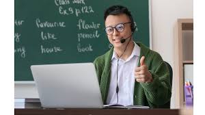 man sitting in front of a laptop,in a classroom setting