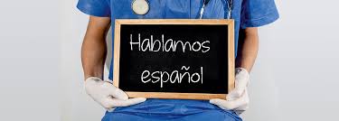 wooden-framed chalkboard with the phrase "Hablamos espa&ntilde;ol" written on it
